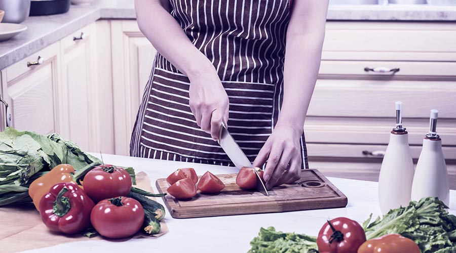 plano fechado, mãos femininas cortando vegetais que ajudam a aumentar a imunidade